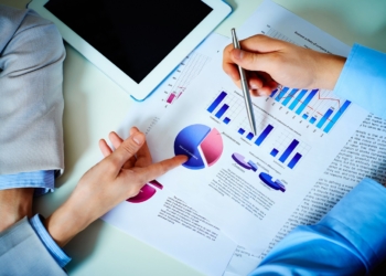 Close-up of female and male hands pointing at business document while discussing it